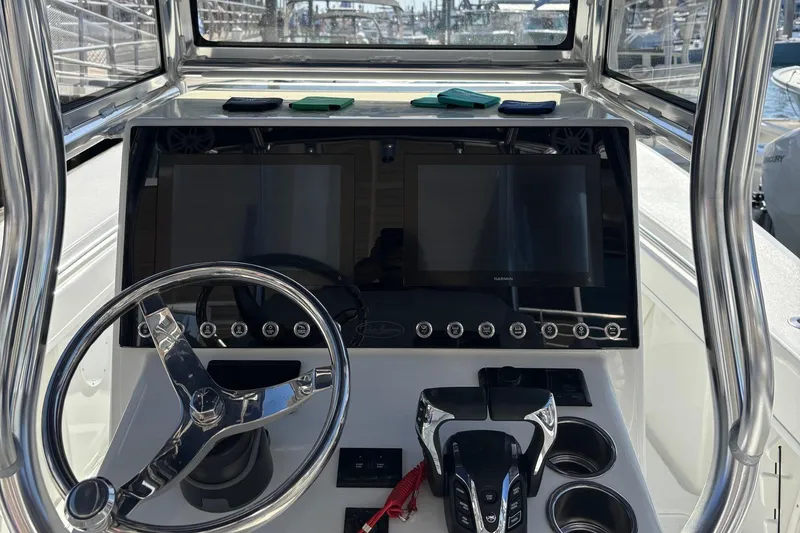 Slide: The Image of 2025 Pair Customs 28 Center Console boat dashboard with dual screens and steering wheel. - 7