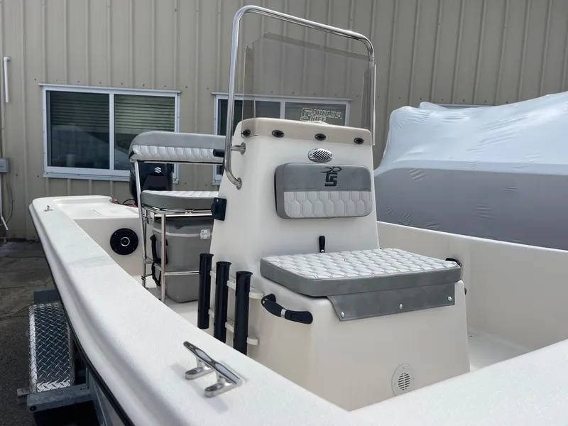 Slide: The Image of 2025 Carolina Skiff E16 JVX CC boat with center console and seating, parked outdoors. - 11