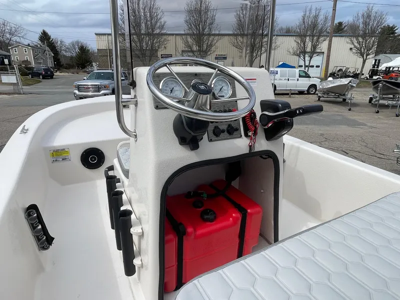 Slide: The Image of 2025 Carolina Skiff E16 JVX CC boat console with steering wheel and red fuel tank. - 6