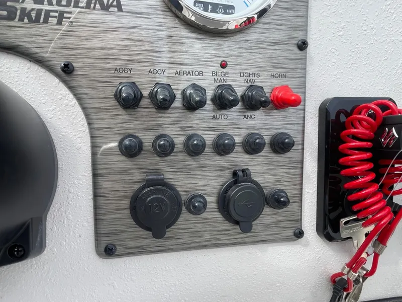 Slide: The Image of Control panel of 2025 Carolina Skiff E16 JVX CC boat with switches and gauges. - 8