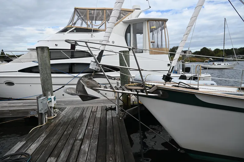 Slide: The Image of 1984 Southern Cross 39 sailboat docked beside a larger yacht on a cloudy day. - 10