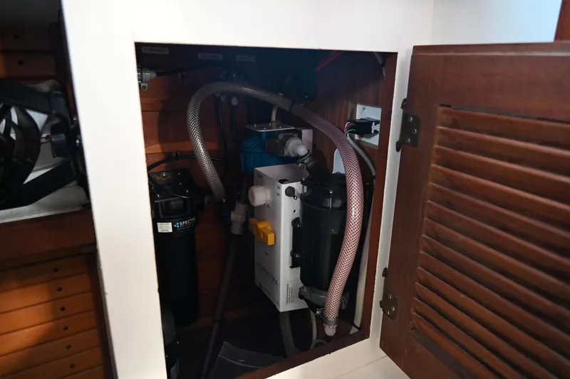 Slide: The Image of 1984 Southern Cross 39 yacht interior showing plumbing and filtration system in a wooden cabinet. - 44