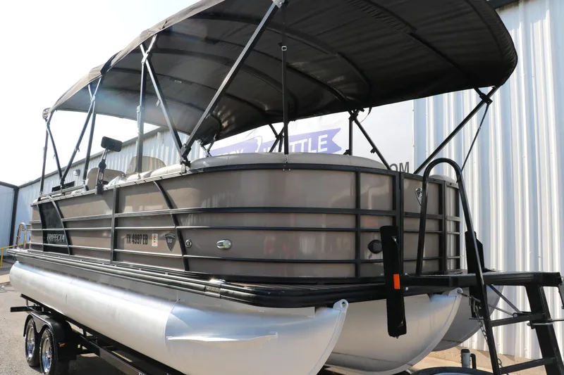 Slide: The Image of 2018 Trifecta 23 RFE pontoon boat with canopy, parked on a trailer. - 10