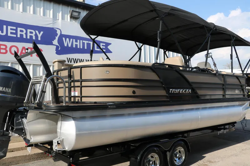Slide: The Image of 2018 Trifecta 23 RFE pontoon boat with canopy on trailer, displayed at dealership. - 2