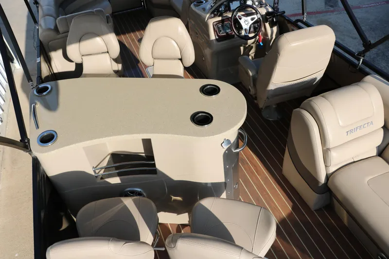 Slide: The Image of Interior of 2018 Trifecta 23 RFE pontoon boat with beige seating and steering console. - 37