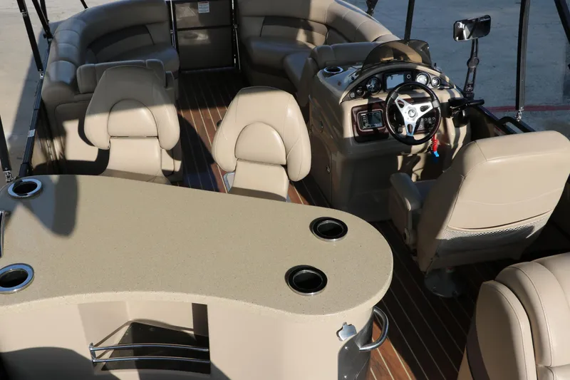 Slide: The Image of Interior of 2018 Trifecta 23 RFE pontoon boat with beige seating and steering console. - 38