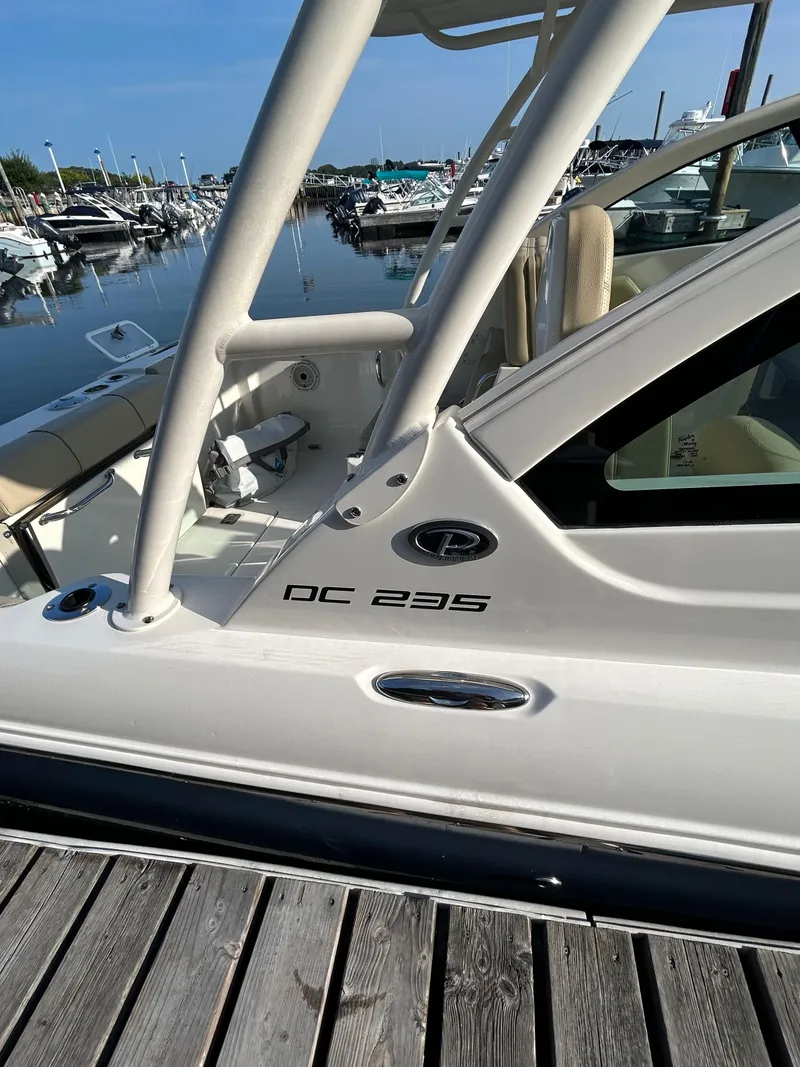 Slide: The Image of 2020 Pursuit DC 235 Dual Console boat docked at marina, side view. - 6