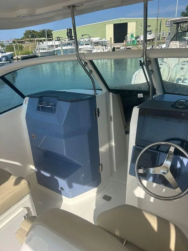 Slide: The Image of 2020 Pursuit DC 235 Dual Console boat interior with steering wheel and seating. - 8