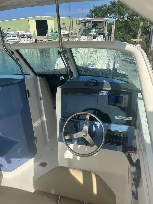 Slide: The Image of 2020 Pursuit DC 235 Dual Console boat interior with steering wheel and dashboard. - 9