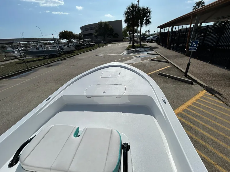 Slide: The Image of 2025 Shallow Sport 22 Sport boat parked in a marina with clear skies. - 20