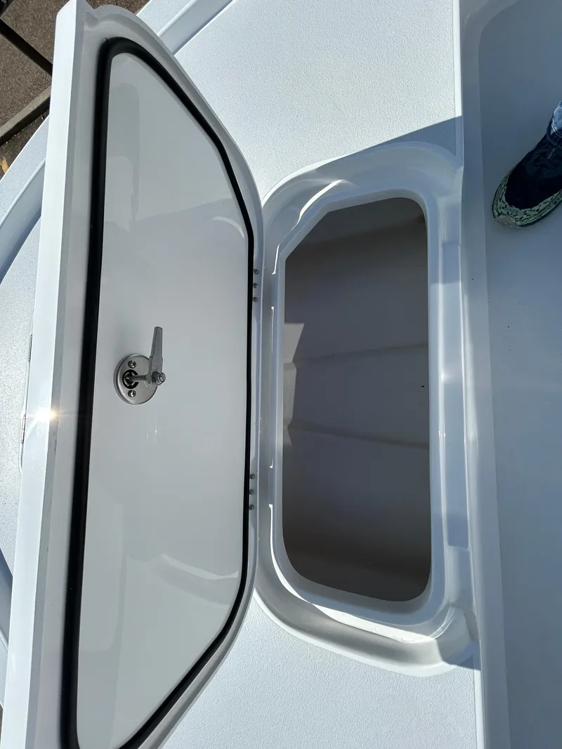 Slide: The Image of 2025 Shallow Sport 22 Sport boat storage compartment with open hatch. - 21
