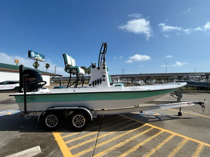 Slide: The Image of 2025 Shallow Sport 22 Sport boat on trailer under clear blue sky. - 4