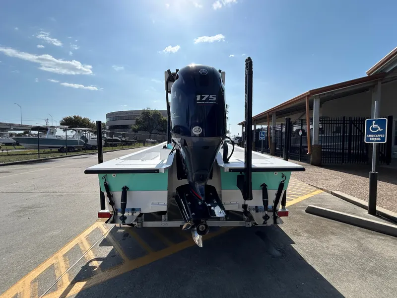 Slide: The Image of 2025 Shallow Sport 22 Sport boat with 175 HP engine, parked near marina. - 6