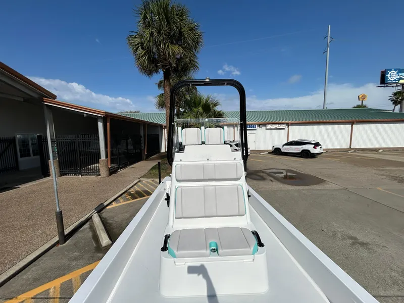 Slide: The Image of 2025 Shallow Sport 22 Sport boat with seating, parked outdoors under clear sky. - 8