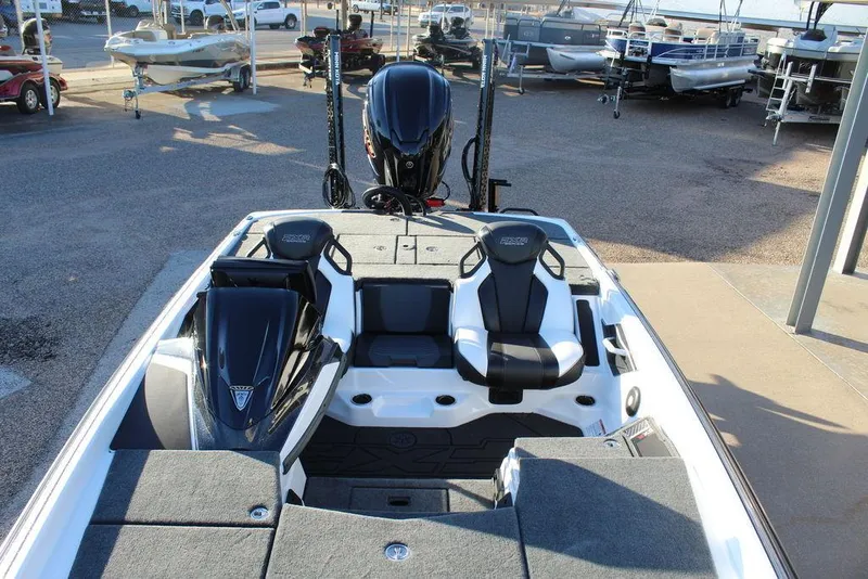 Slide: The Image of 2025 Skeeter FXR20L boat interior with dual seats and motor, displayed at a dealership. - 13
