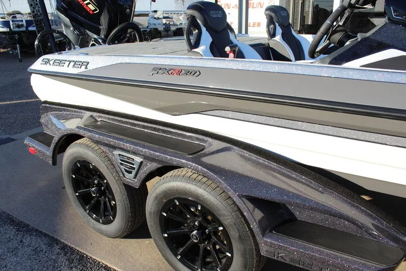 Slide: The Image of 2025 Skeeter FXR20L boat on trailer, featuring sleek design and black wheels. - 23