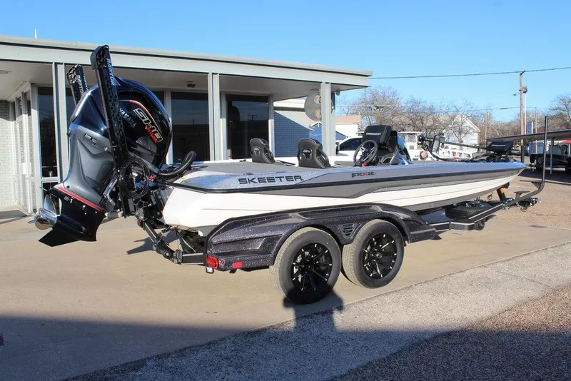 Slide: The Image of 2025 Skeeter FXR20L boat with trailer, parked outdoors near a building. - 3