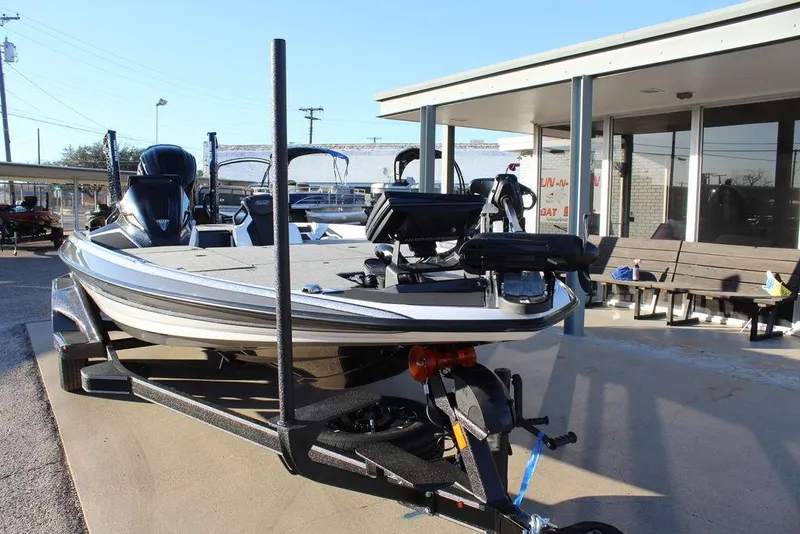 Slide: The Image of 2025 Skeeter FXR20L bass boat on trailer, parked outside a building. - 8