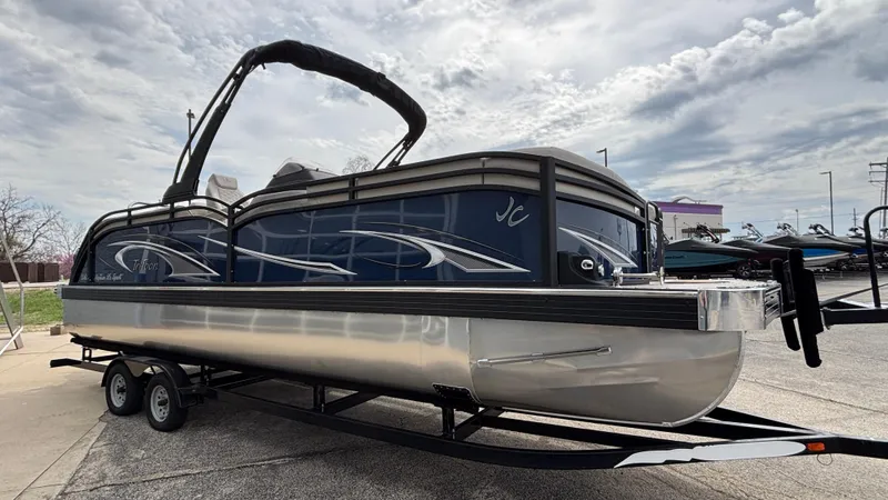 Slide: The Image of 2025 JC Neptoon 25TT Sport pontoon boat on trailer, under cloudy sky. - 4