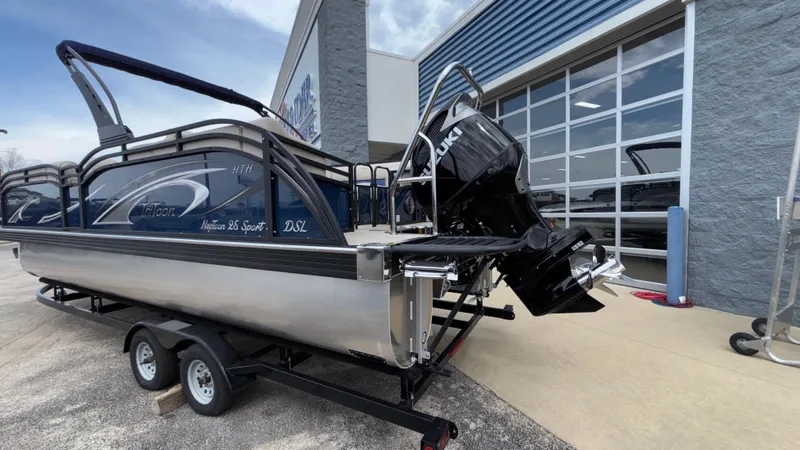Slide: The Image of 2025 JC Neptoon 25TT Sport pontoon boat on trailer outside a showroom. - 5