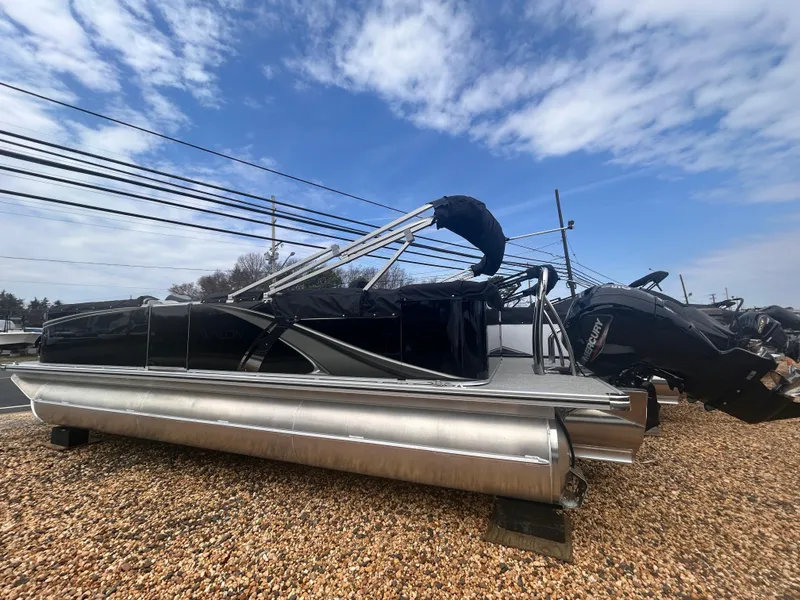 Slide: The Image of 2025 Avalon 2385 LSZ pontoon boat on gravel lot under blue sky. - 1