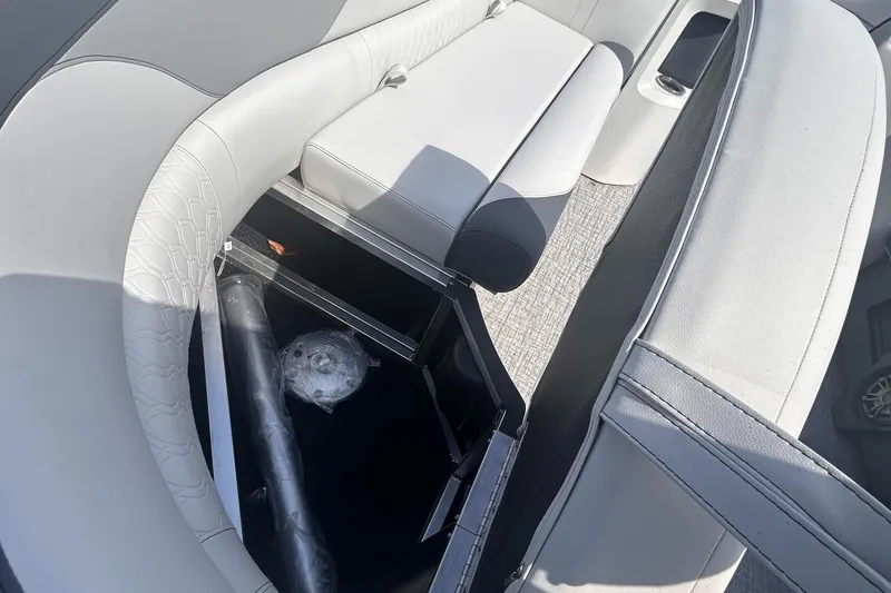 Slide: The Image of 2025 Avalon 2385 LSZ boat interior with open storage compartment and cushioned seating. - 11