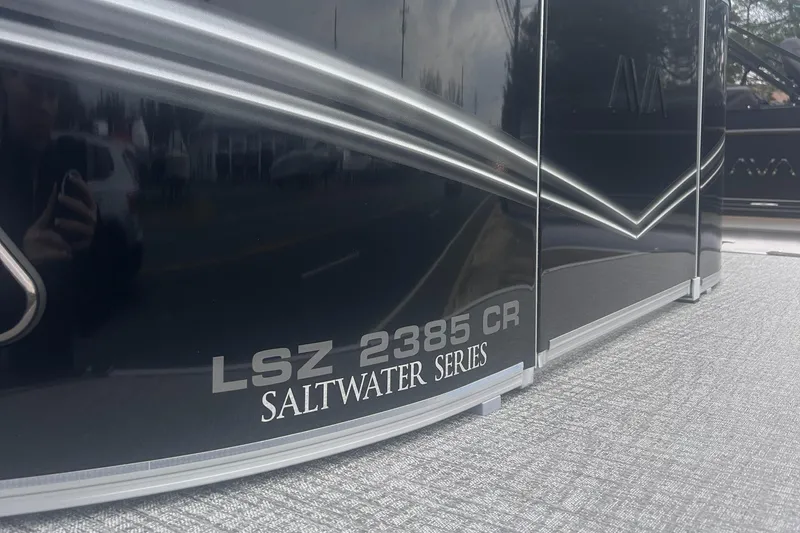Slide: The Image of 2025 Avalon 2385 LSZ Saltwater Series boat, sleek black exterior with reflective finish. - 2