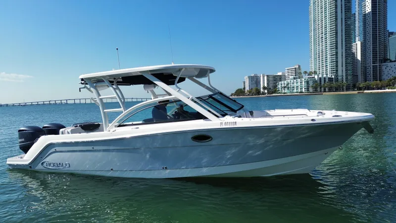 Slide: The Image of 2021 Robalo R317 Dual Console boat on water near city skyline. - 20