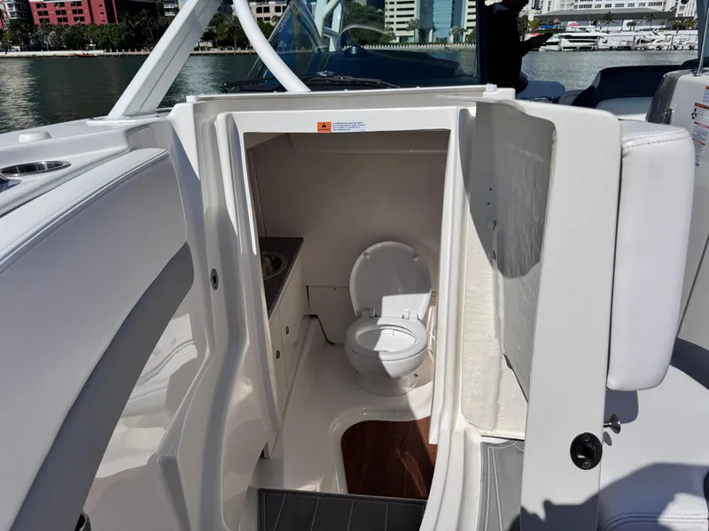 Slide: The Image of 2021 Robalo R317 Dual Console boat interior with compact marine toilet. - 24