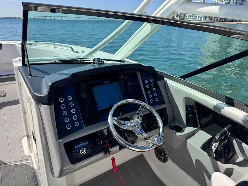 Slide: The Image of 2021 Robalo R317 Dual Console boat dashboard with steering wheel and navigation system. - 25