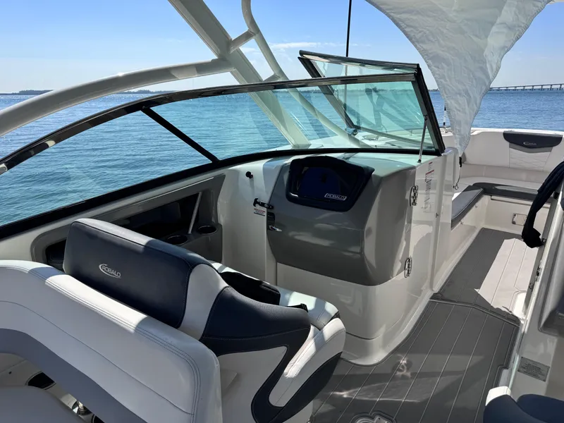 Slide: The Image of 2021 Robalo R317 Dual Console boat interior with helm, seating, and ocean view. - 34