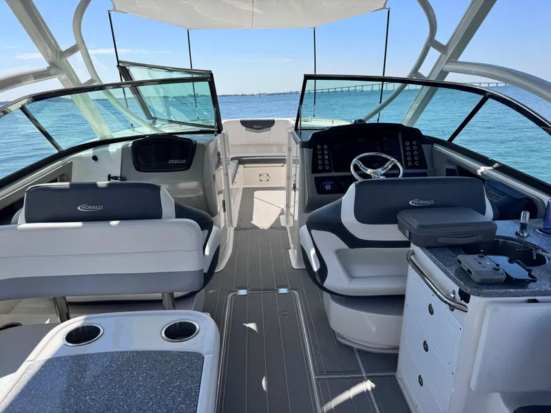 Slide: The Image of 2021 Robalo R317 Dual Console boat interior with seating and helm, on calm blue water. - 36