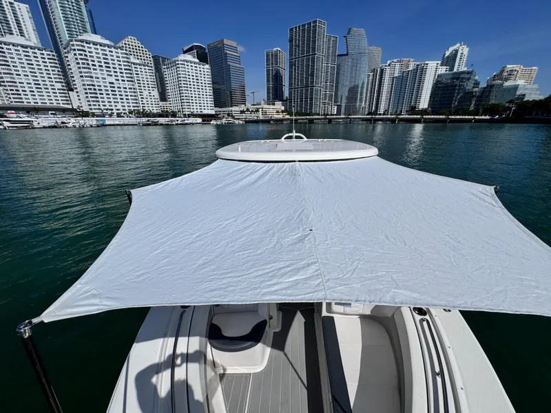 Slide: The Image of 2021 Robalo R317 Dual Console boat with canopy, city skyline in background. - 40