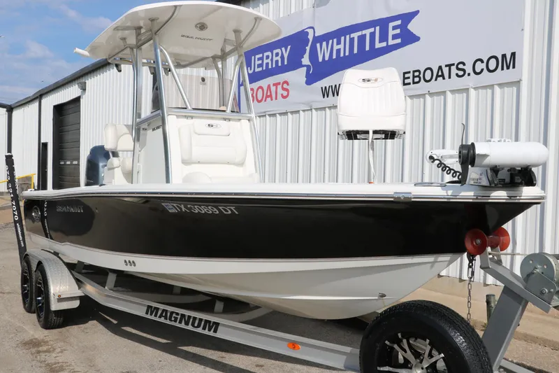 Slide: The Image of 2017 Sea Hunt BX22BR boat on Magnum trailer, parked outside dealership. - 11