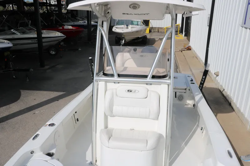 Slide: The Image of 2017 Sea Hunt BX22BR boat with T-top and seating, displayed in a marina setting. - 18