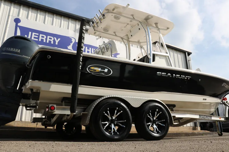 Slide: The Image of 2017 Sea Hunt BX22BR boat on trailer, Yamaha engine, parked outside dealership. - 2