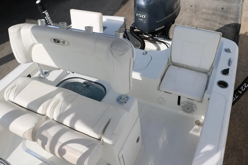 Slide: The Image of 2017 Sea Hunt BX22BR boat interior with white seating and Yamaha 150 engine. - 24