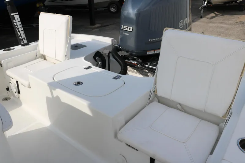 Slide: The Image of 2017 Sea Hunt BX22BR boat interior with white seating and Yamaha 150 engine. - 33