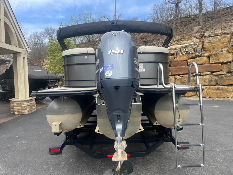 Slide: The Image of 2019 Starcraft EXS 3 pontoon boat with 150 HP engine, parked on a trailer. - 6