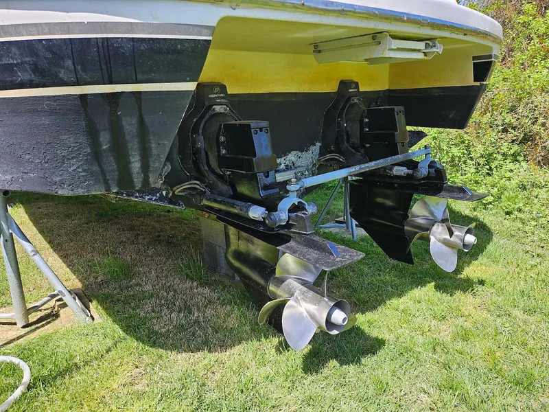 Slide: The Image of 2002 Wellcraft 38 Excalibur boat stern with dual propellers on grass. - 13