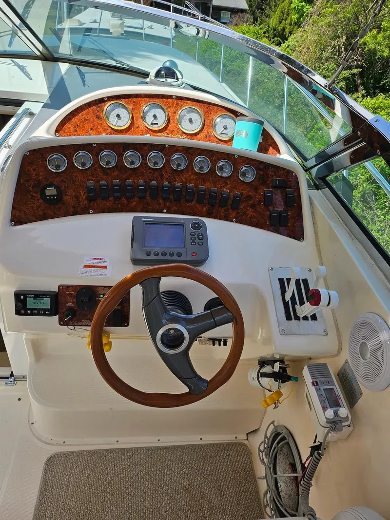 Slide: The Image of 2002 Wellcraft 38 Excalibur boat dashboard with steering wheel and control panel. - 2