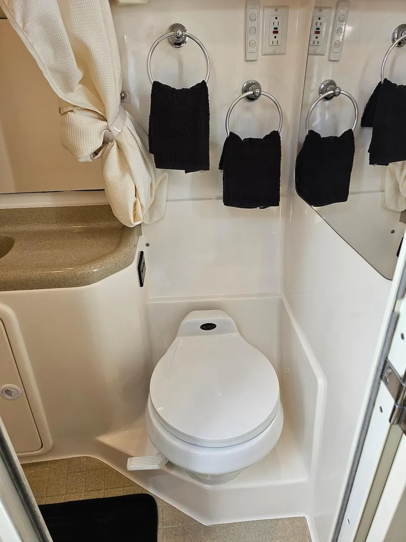 Slide: The Image of 2002 Wellcraft 38 Excalibur boat bathroom with toilet, sink, and towels. - 7