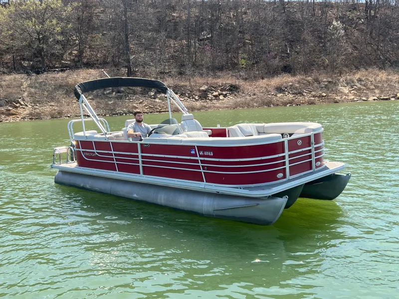 Slide: The Image of Red 2014 Starcraft SLS3 pontoon boat on a lake with a person steering. - 6