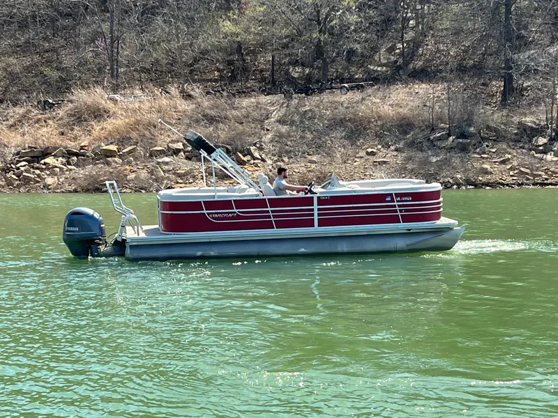Slide: The Image of 2014 Starcraft SLS3 pontoon boat cruising on a lake with a scenic background. - 8