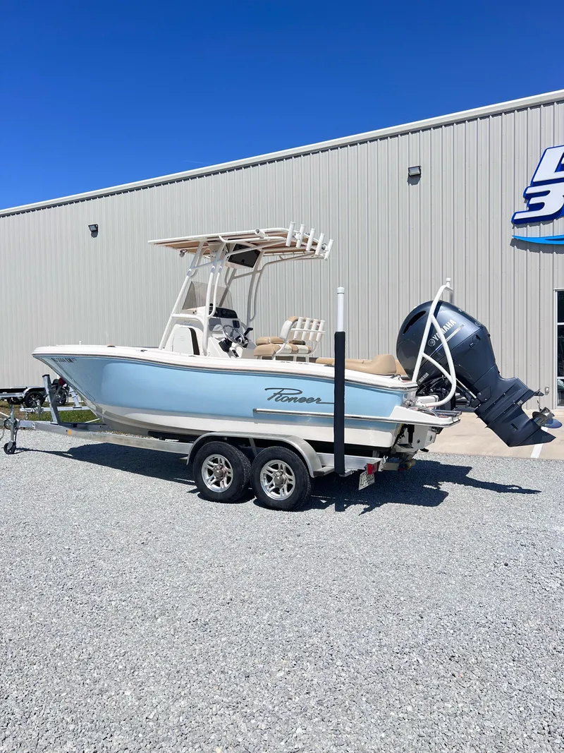 Slide: The Image of 2019 Pioneer 202 Islander boat on trailer, parked outside a building. - 1