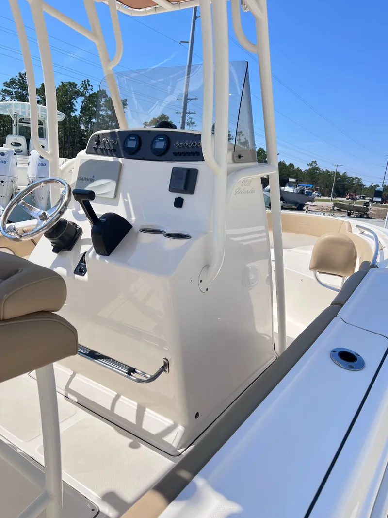 Slide: The Image of 2019 Pioneer 202 Islander boat console with steering wheel and controls, under clear blue sky. - 5
