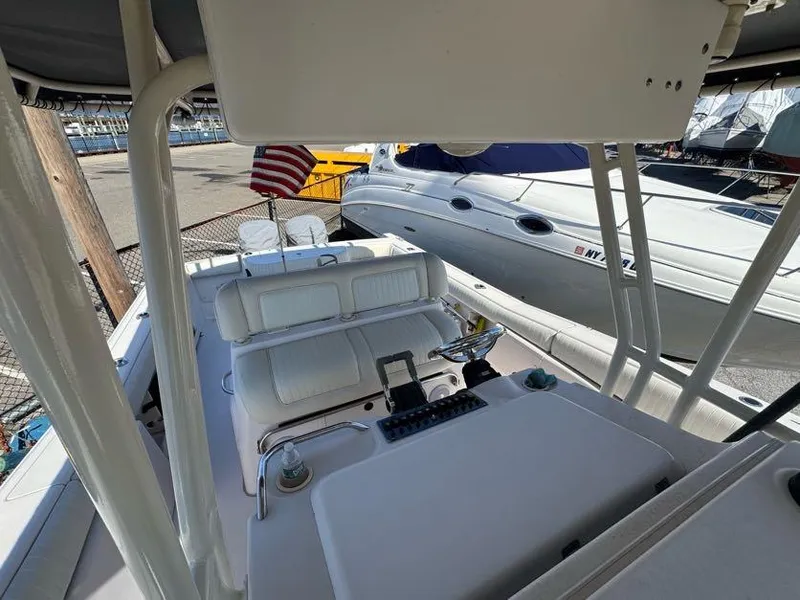 Slide: The Image of 2000 Grady-White Bimini 306 boat interior with seating and control panel, docked near other boats. - 11