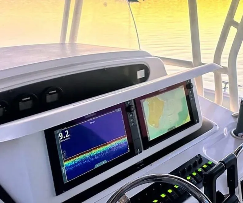 Slide: The Image of Dashboard of 2000 Grady-White Bimini 306 with dual navigation screens. - 13