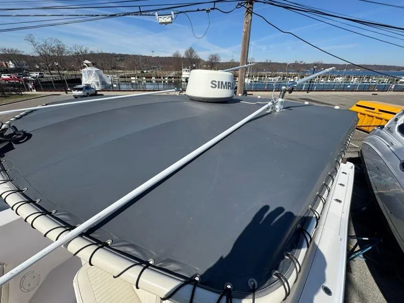 Slide: The Image of 2000 Grady-White Bimini 306 boat with a covered deck, docked near a marina. - 19