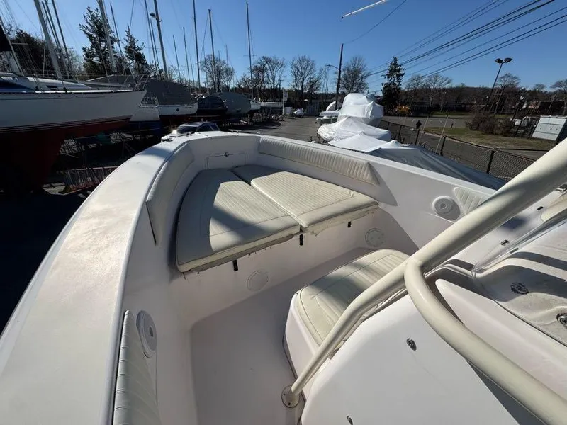 Slide: The Image of 2000 Grady-White Bimini 306 boat interior with cushioned seating, docked among other boats. - 22